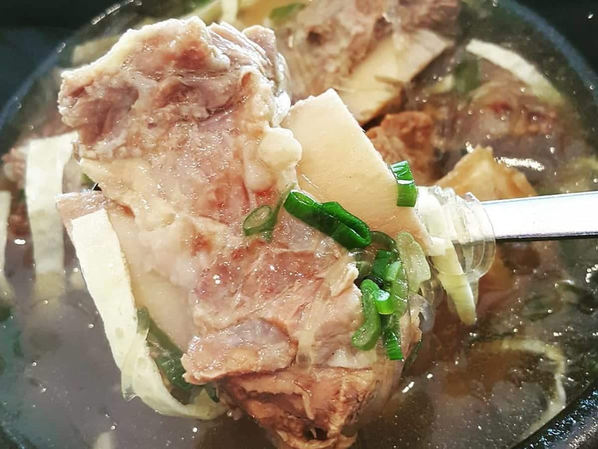 Clear beef broth with short ribs and radish in a white bowl
