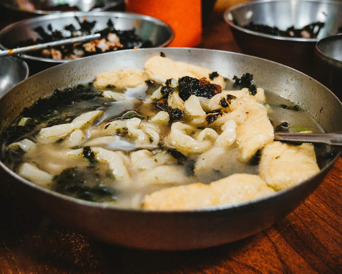 Wide hand-cut wheat noodles in clear broth with seaweed garnish