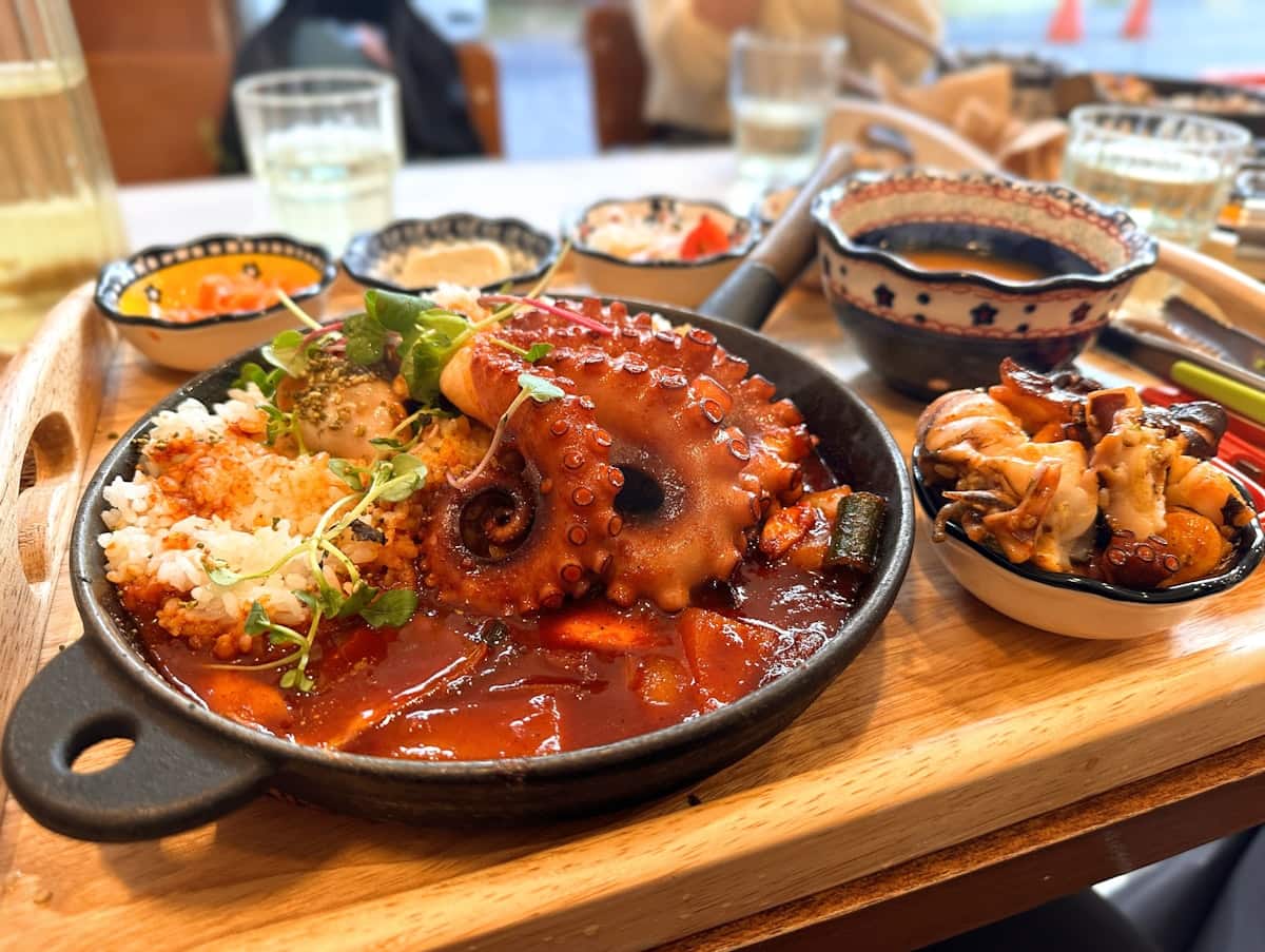 Whole octopus tentacles in spicy red sauce over rice