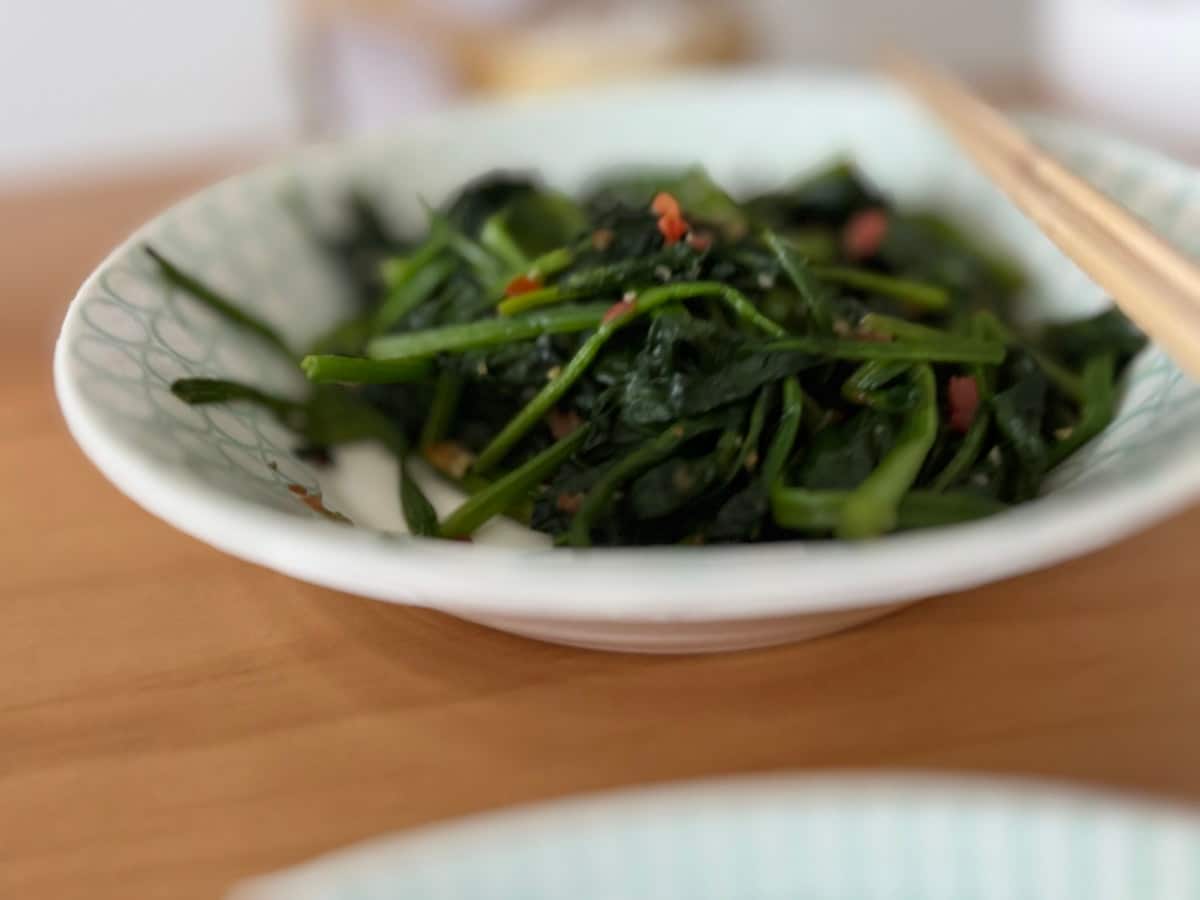 Seasoned blanched spinach in a bowl with garlic and sesame
