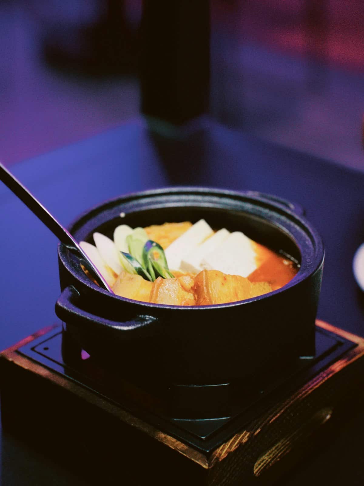 Sundubu jjigae with soft tofu, scallions, and pork belly in a bubbling stone pot