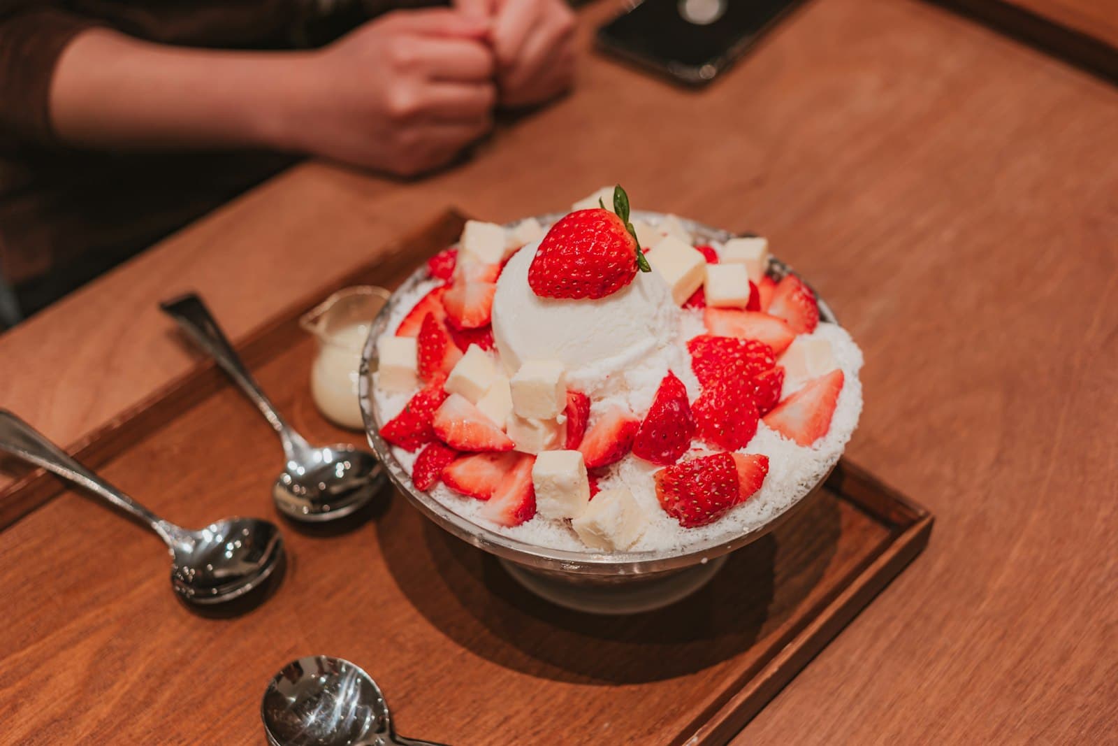 A bowl of shaved ice bingsu with strawberries and cream