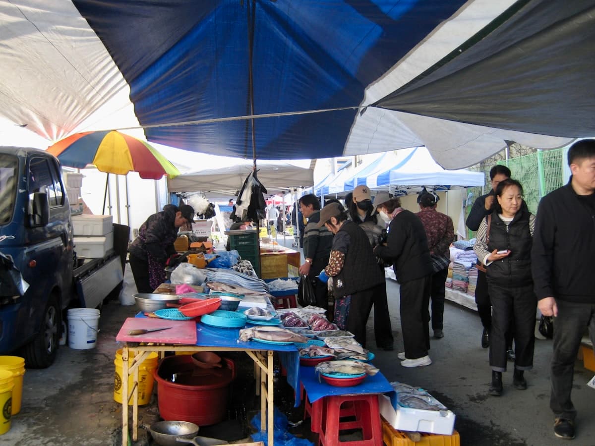 A busy outdoor Korean market with food stalls