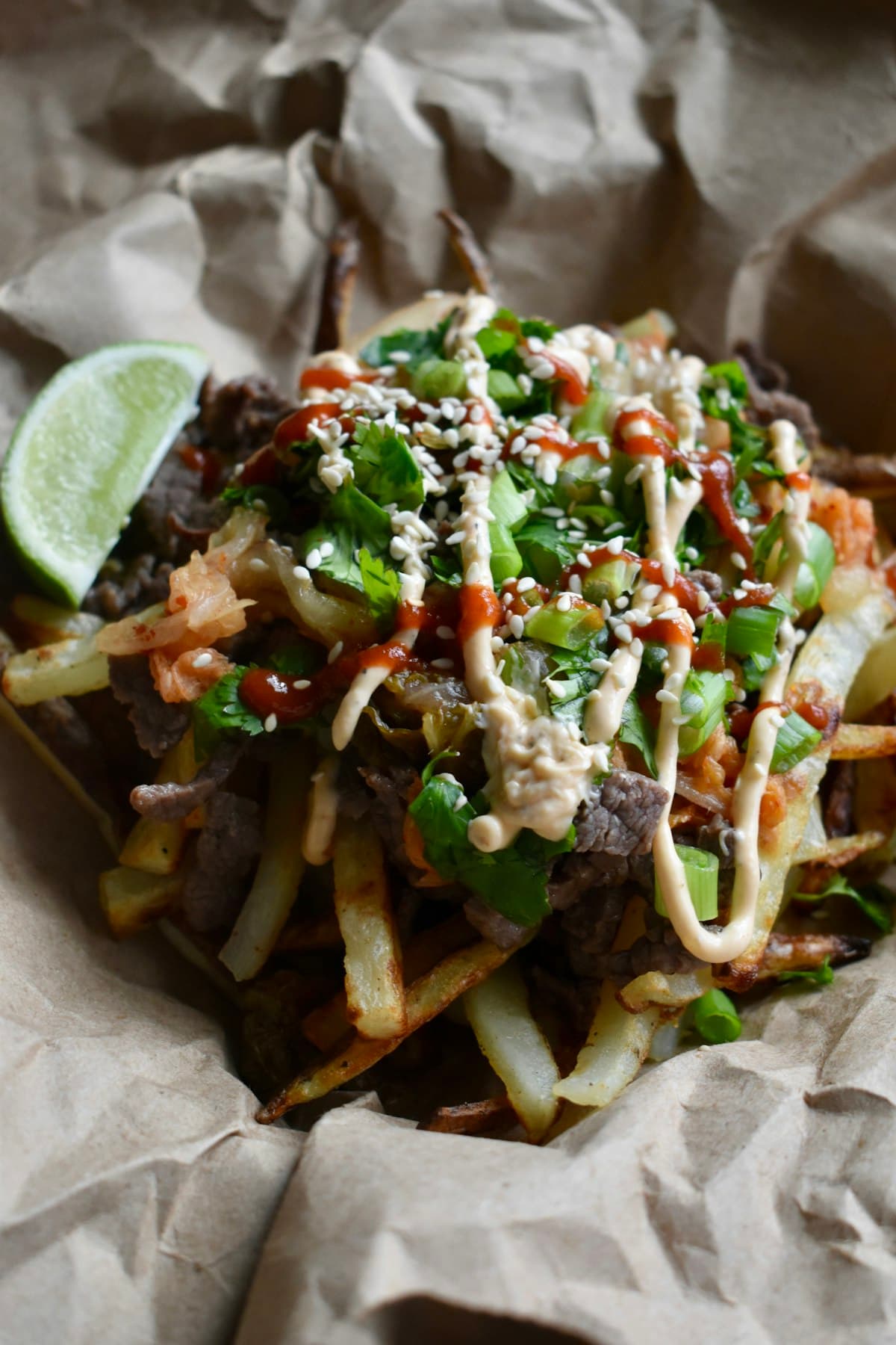 Korean-style beef fries topped with kimchi, cilantro, and sauce, food-truck style