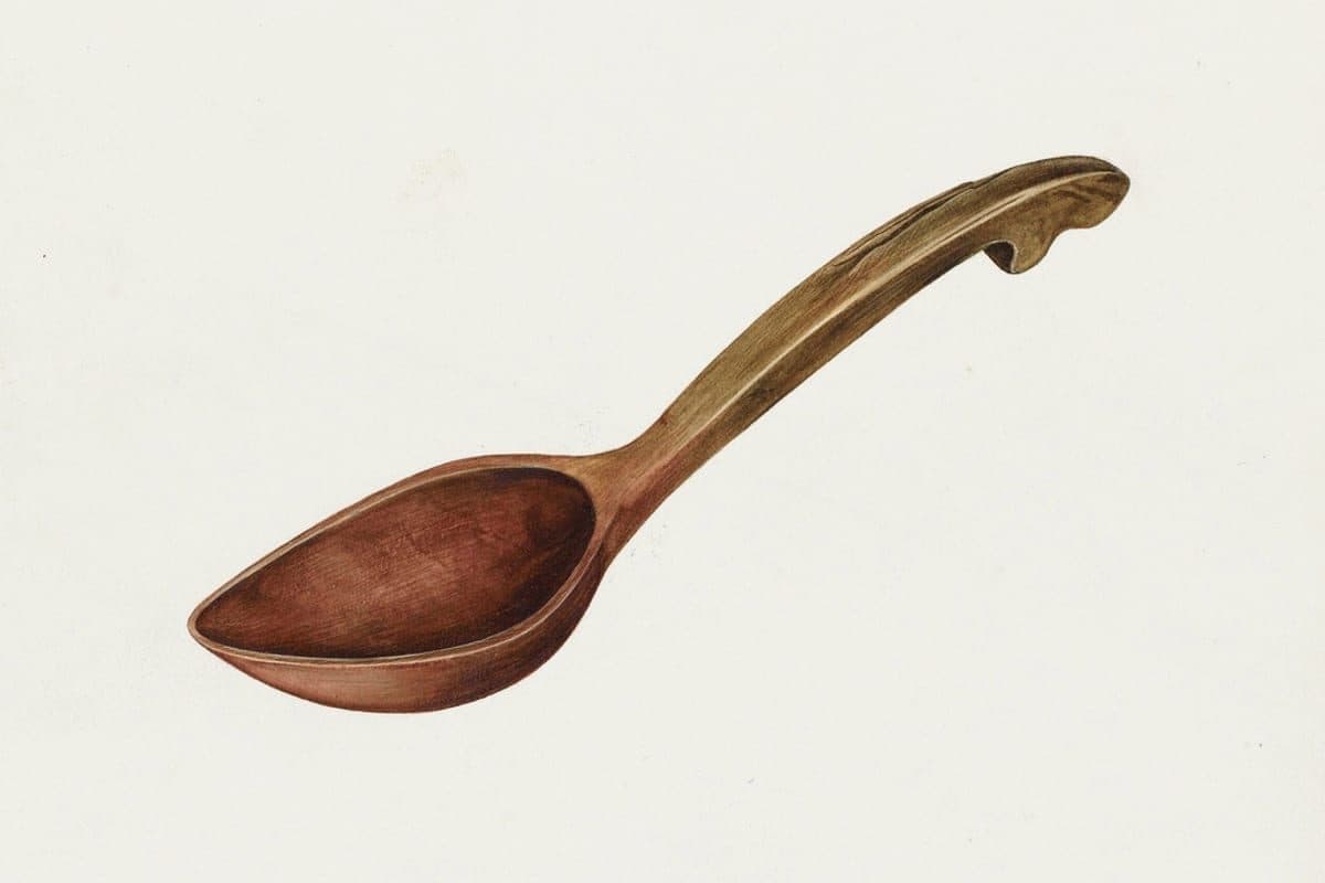 A wooden spoon resting in cooked rice