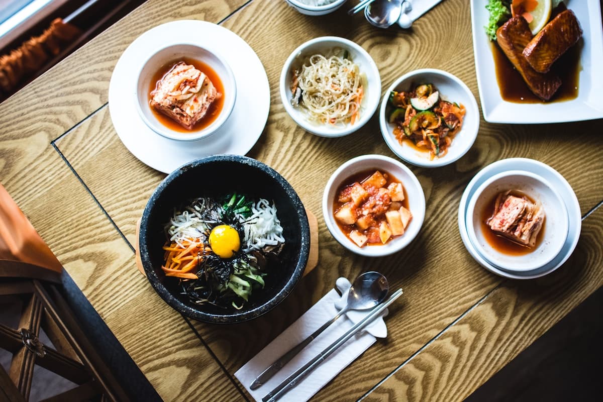 A Korean restaurant table spread with bibimbap and side dishes