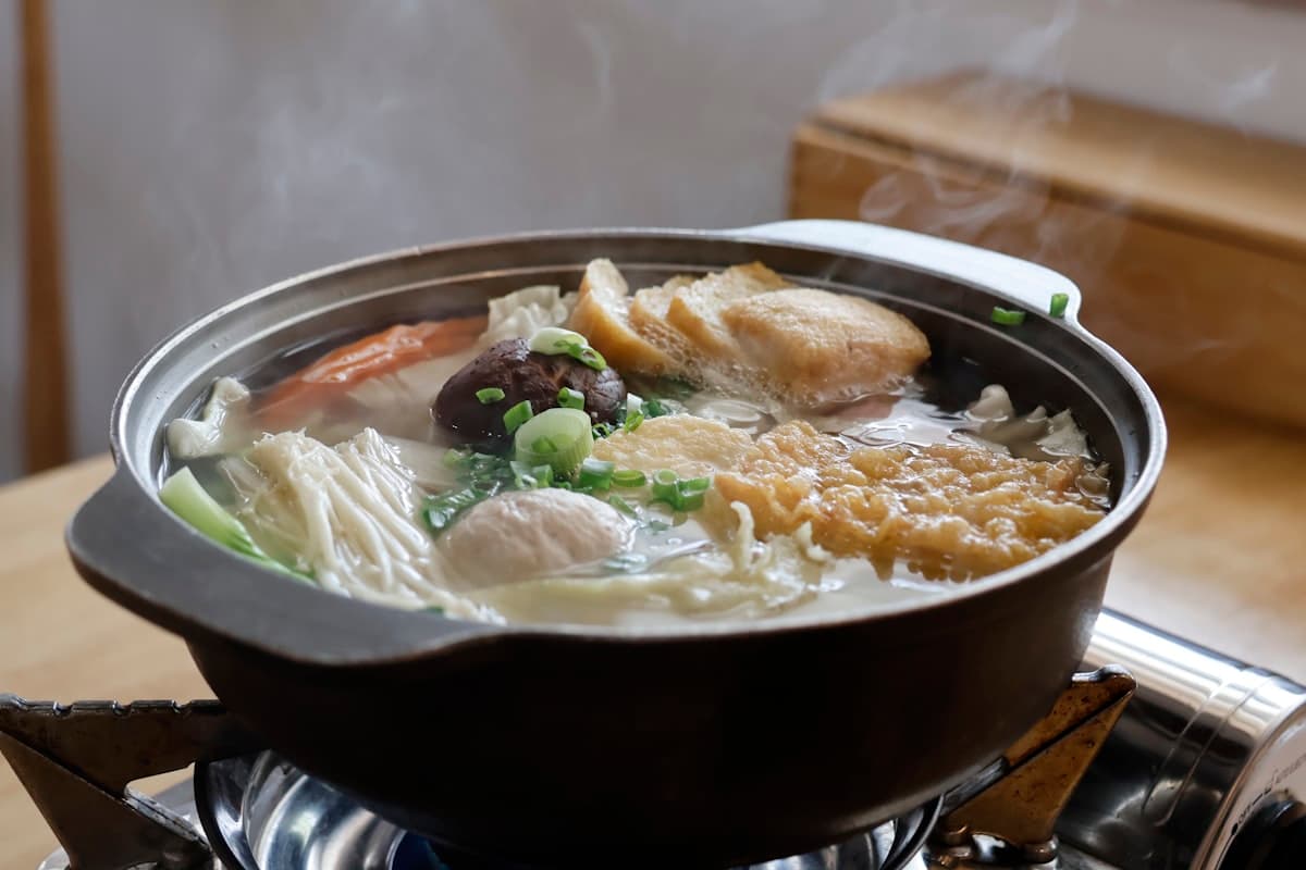 A steaming hot pot of stew at the center of a table