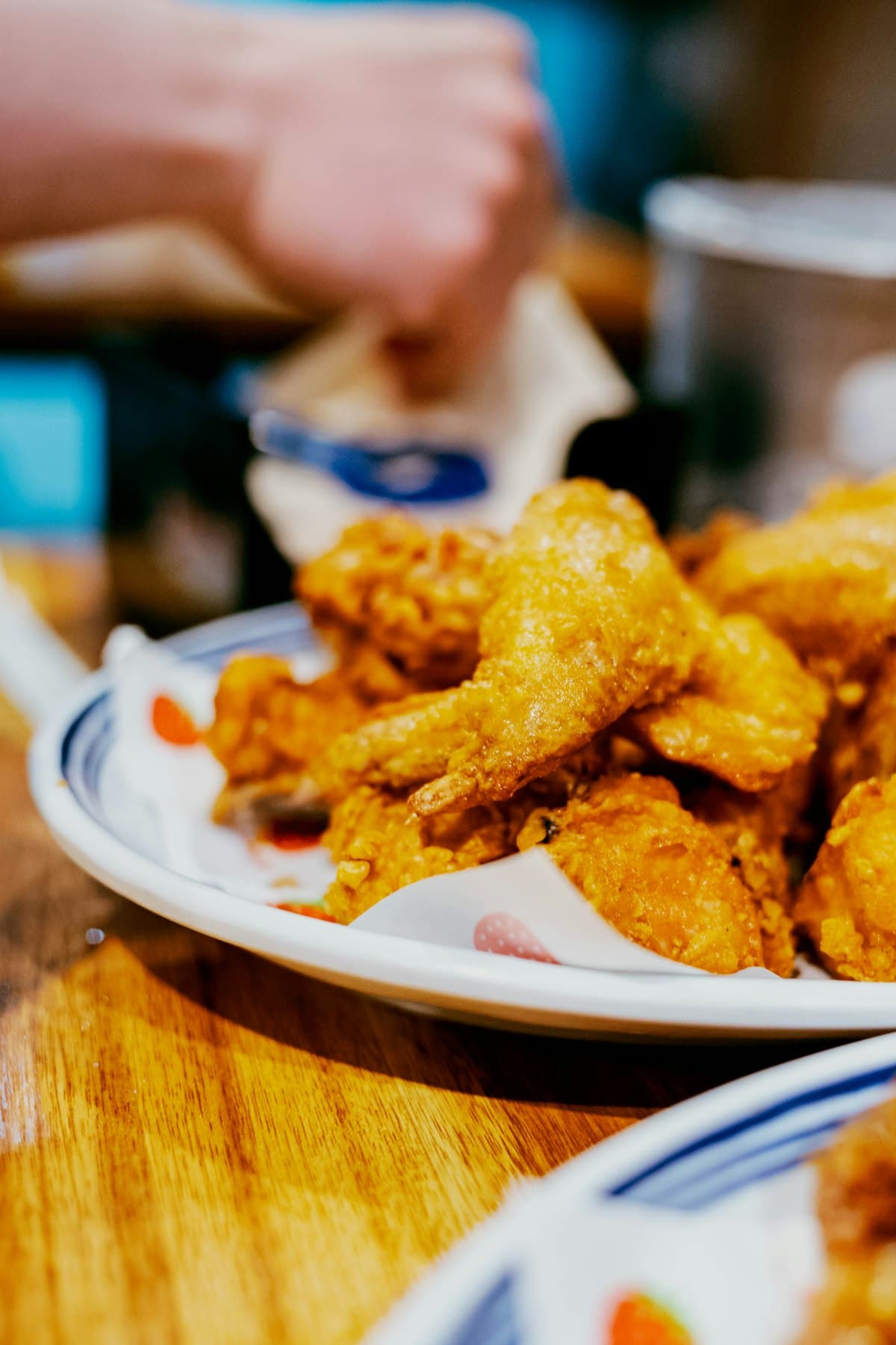 Glossy glazed Korean fried chicken wings on traditional patterned plates