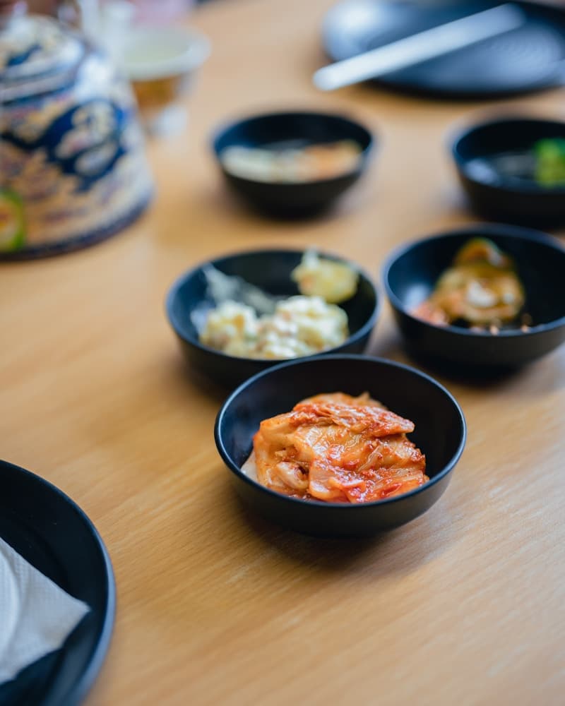 A Korean table set with several small side-dish bowls including kimchi