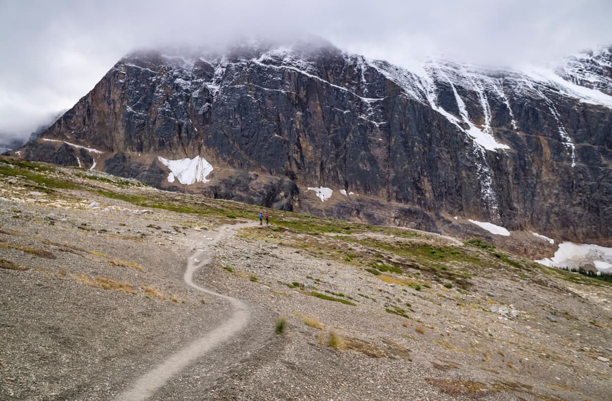 A rocky mountain trail beneath a snow-capped peak