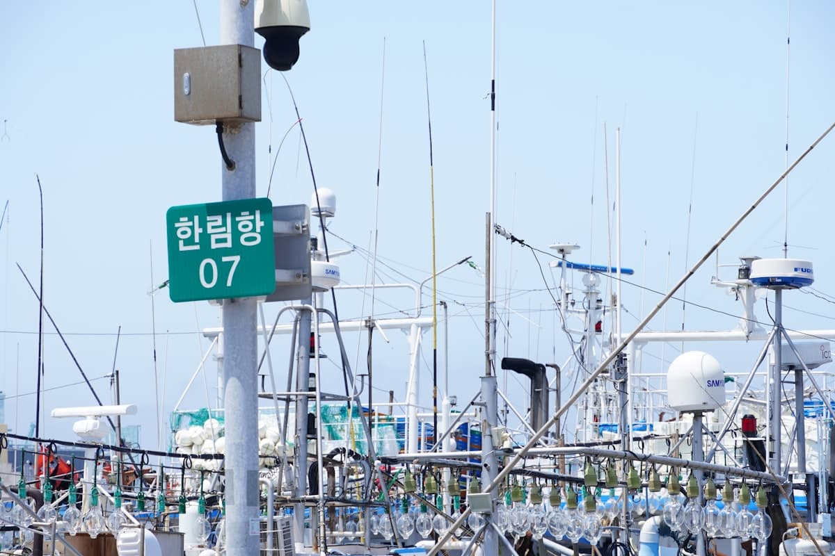 A Korean harbor sign among fishing boat masts