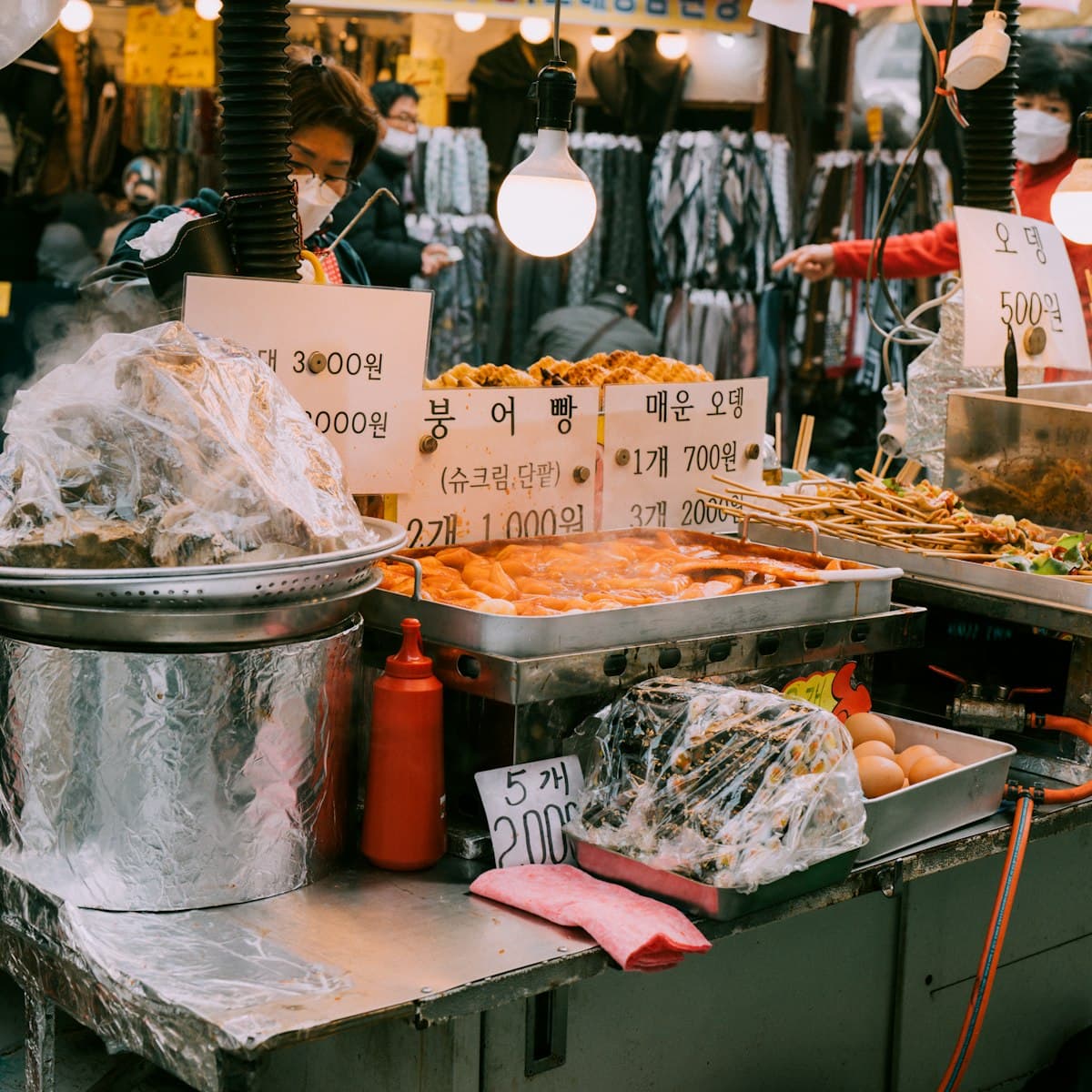 A Korean street food stall selling odeng (fish cake) with a price sign