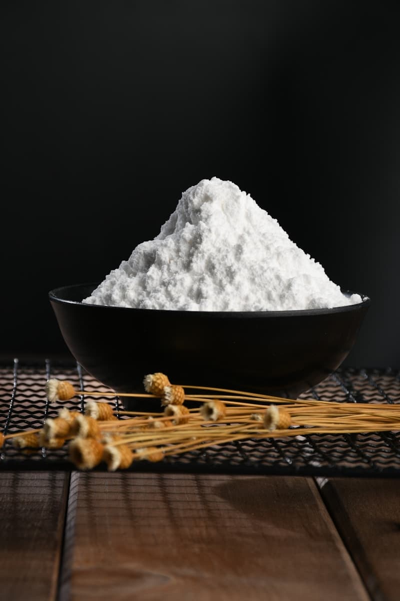A mound of fine white potato starch in a black bowl