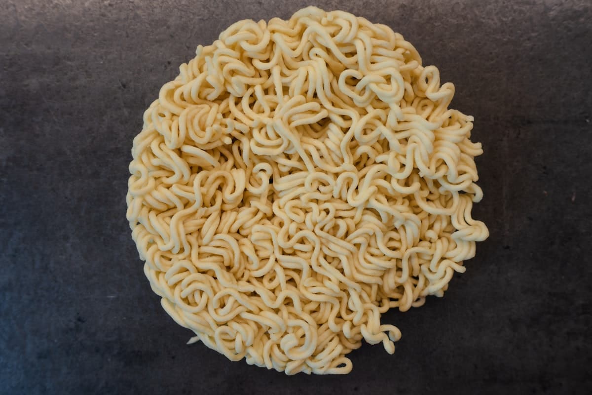 A plain dried instant noodle block, no packaging visible