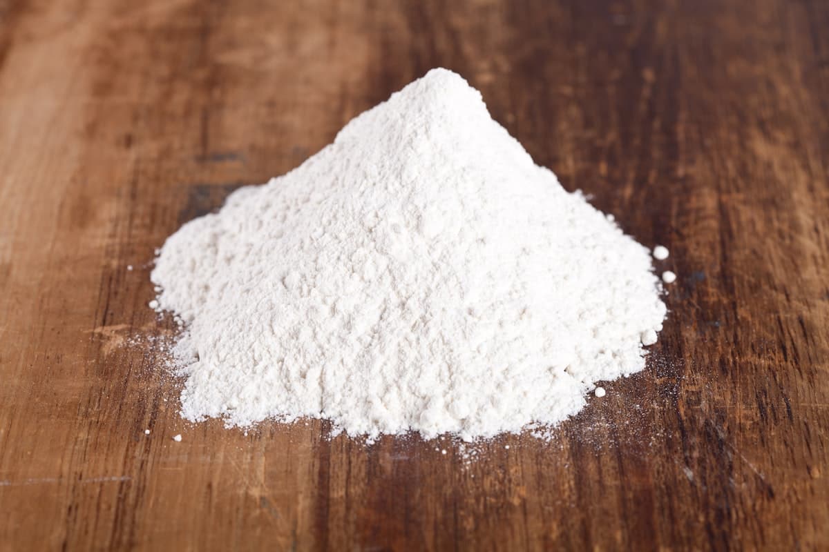 A pile of fine white rice flour on a wooden surface
