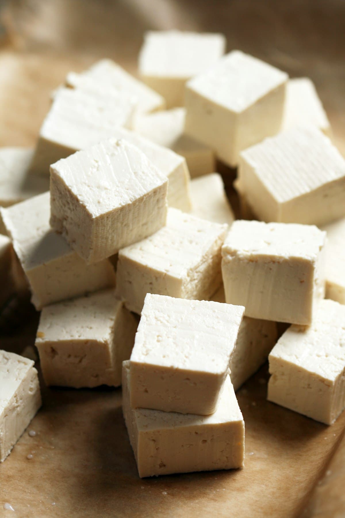 Stacked cubes of fresh white tofu on a cutting board