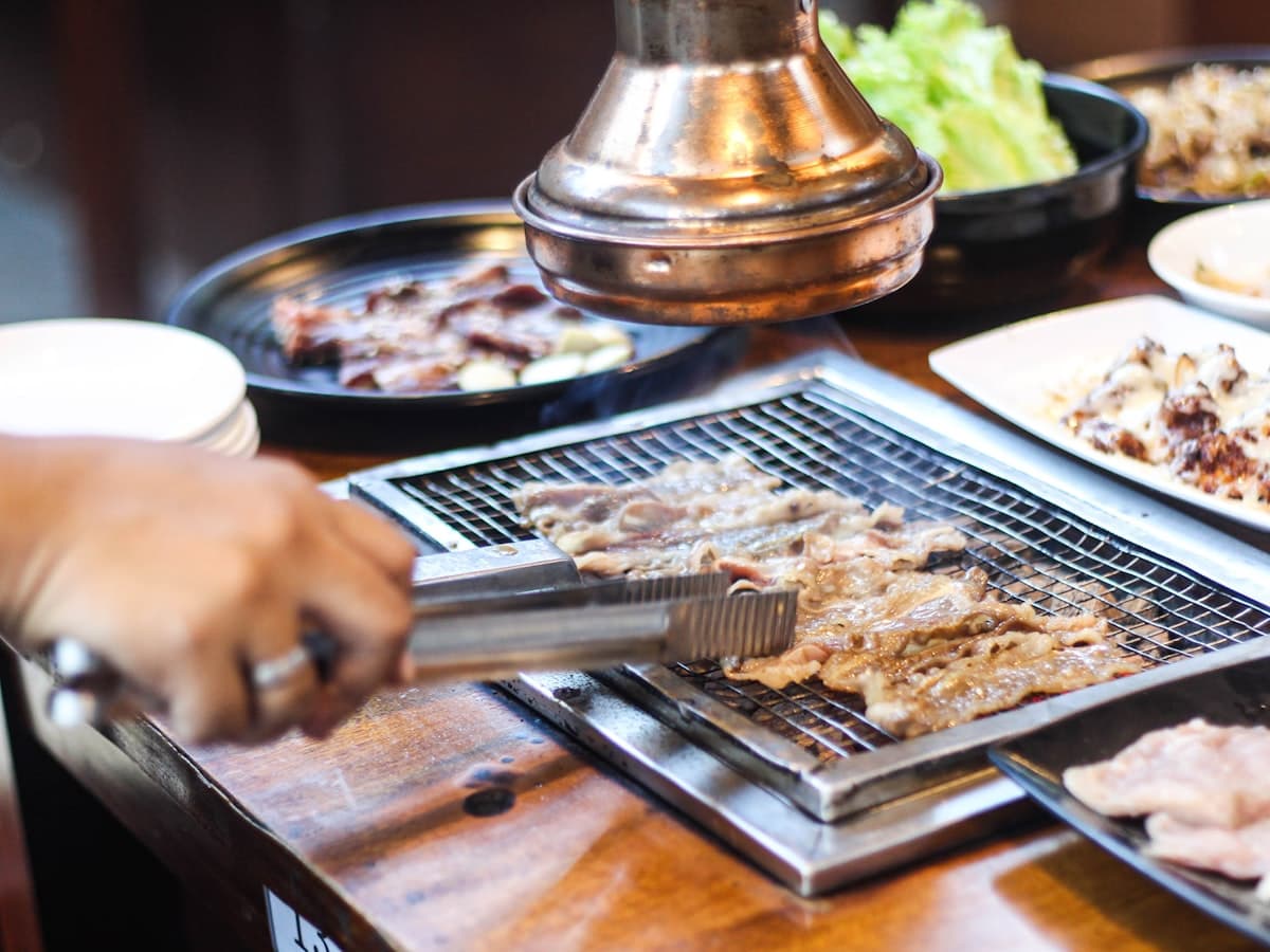 Marinated Korean short ribs grilling on a tabletop grill