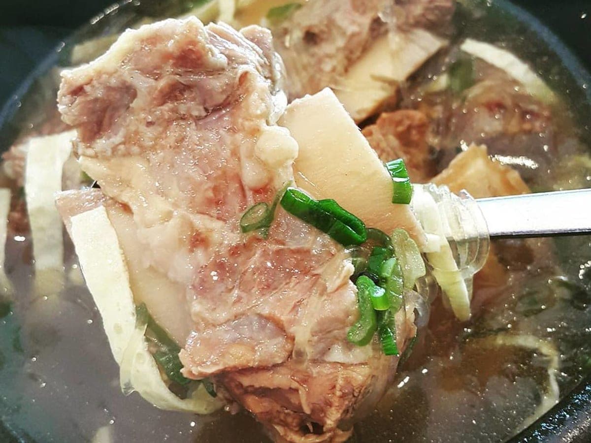 Clear beef broth with short ribs and radish in a white bowl
