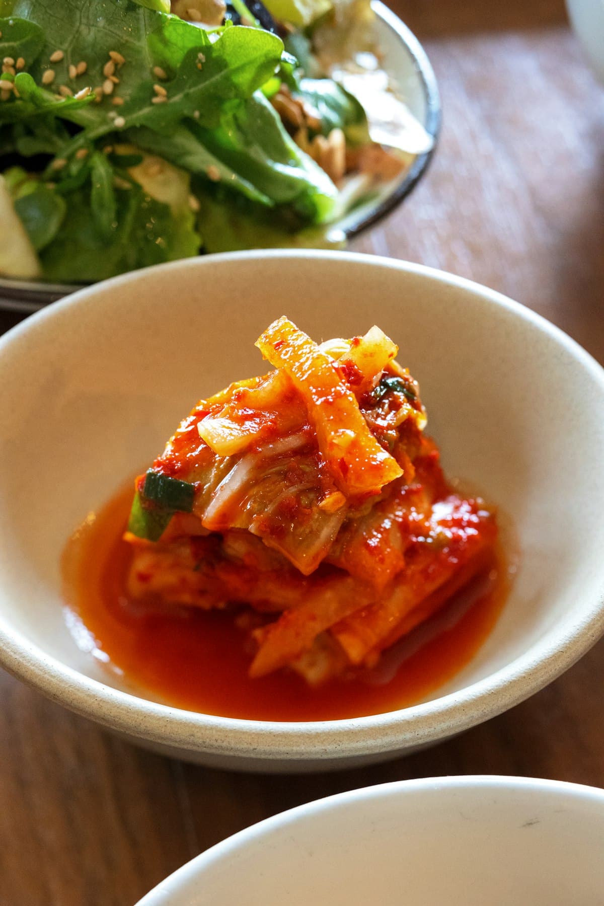 Cubed radish kimchi coated in red chili paste in a bowl