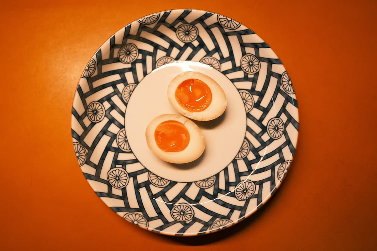 Halved soft-boiled eggs with jammy yolks in a soy marinade