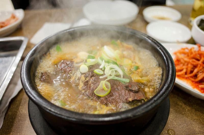Beef soup with scallions and radish simmering in a hot stone pot
