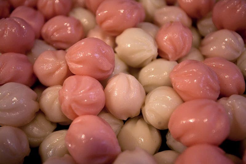 Pink and white pinched half-moon rice cakes stacked together