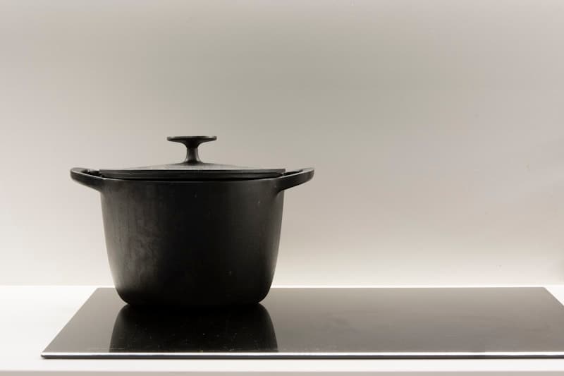 A black lidded cast iron cooking pot