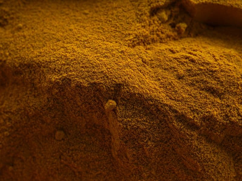 Close-up texture of vivid yellow curry powder