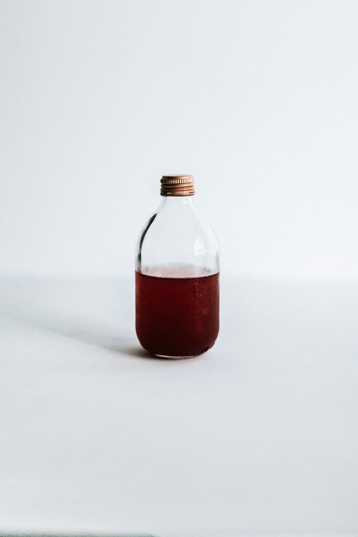 A glass bottle filled with dark seasoned liquid