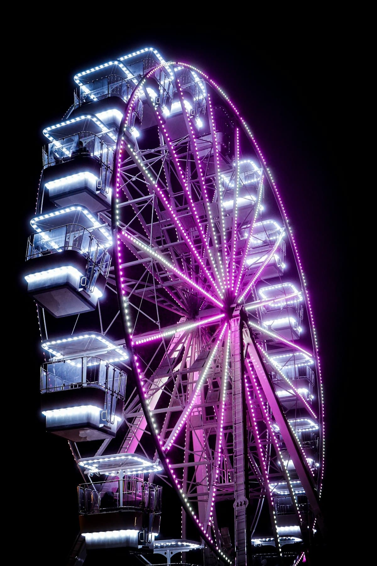A brightly lit ferris wheel against a dark night sky