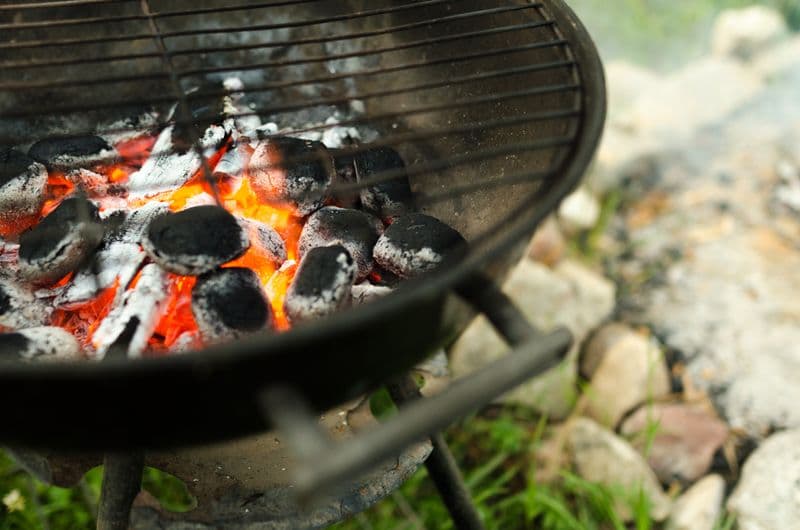 Glowing charcoal briquettes inside an outdoor grill