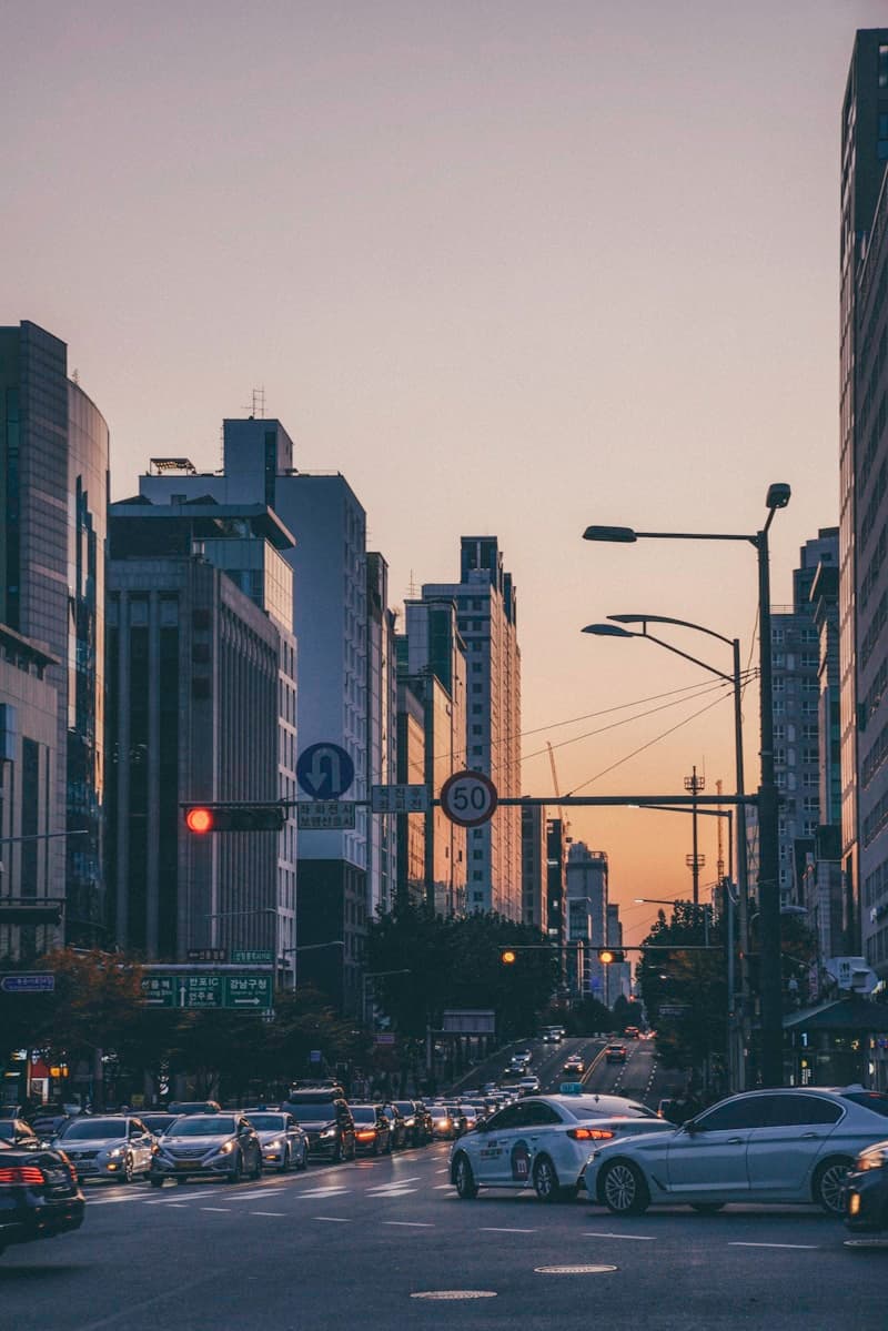 A busy city street lined with tall buildings at dusk