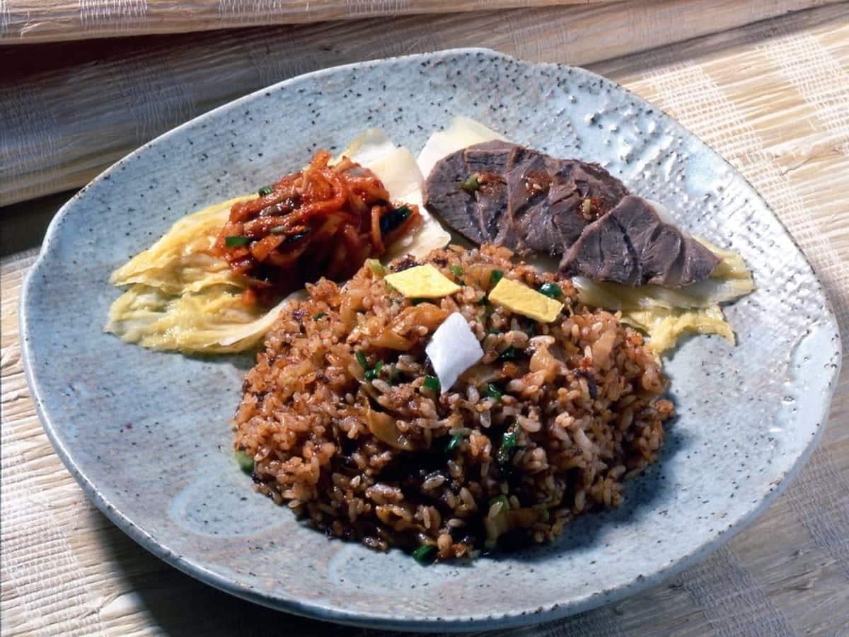 Korean fried rice on a plate topped with a fried egg and vegetables