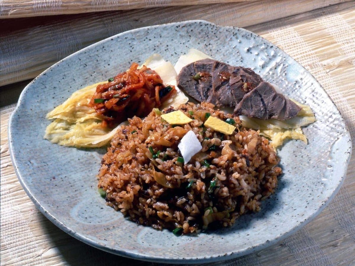 Korean fried rice on a plate topped with a fried egg and vegetables