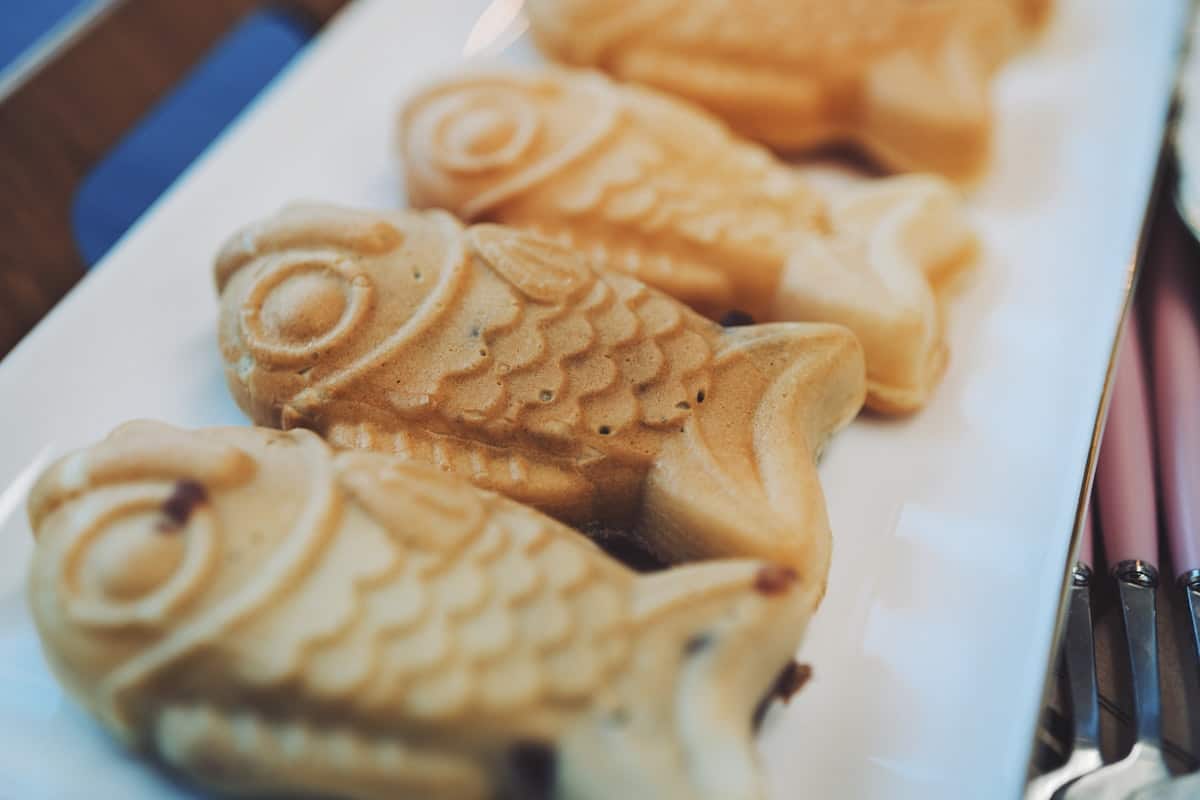 Golden fish-shaped pastries filled with sweet filling on a plate