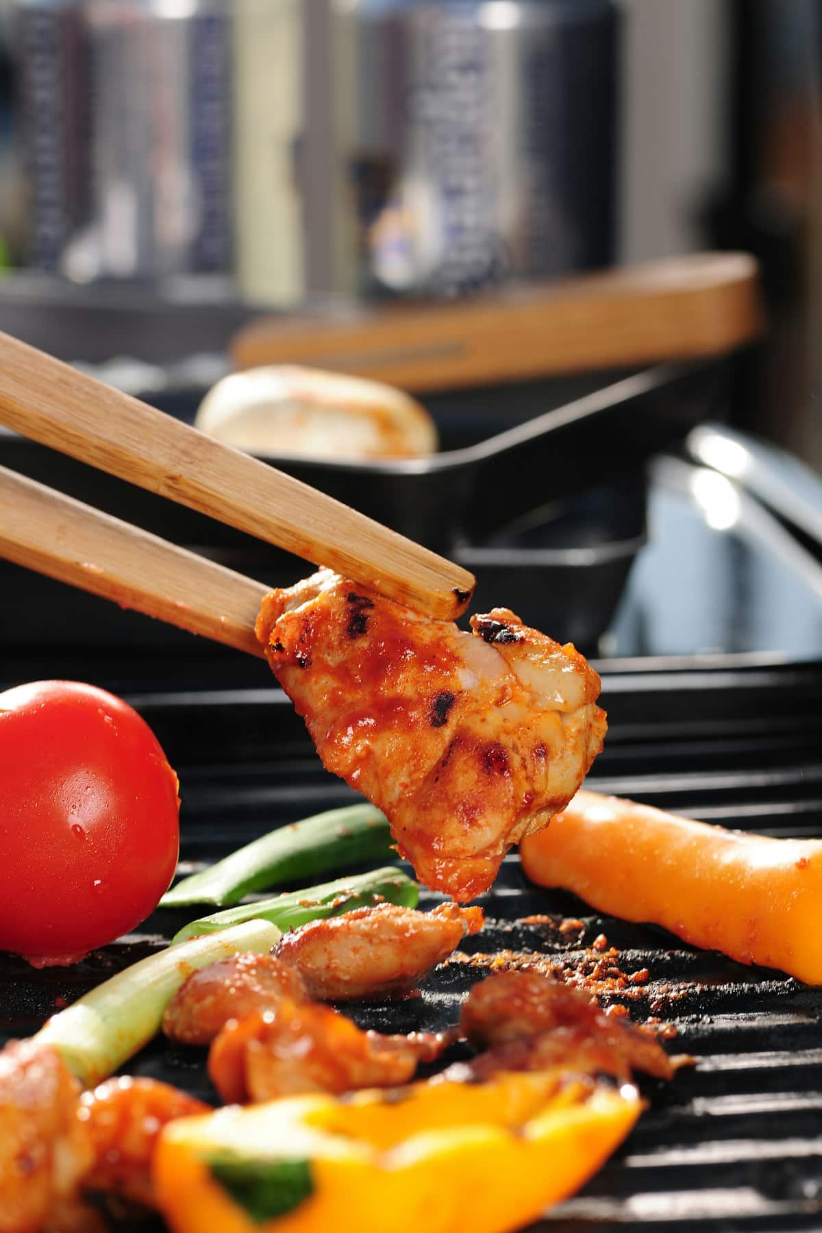 Sliced marinated chicken thigh grilled with onion, glossy with sauce