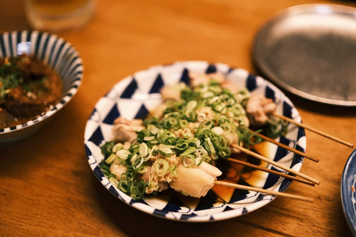 Grilled chicken skewers topped with chopped green onion