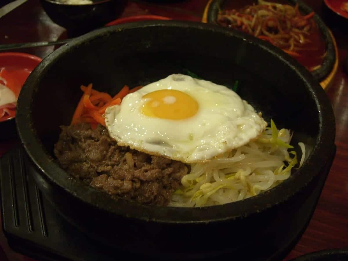 Stone pot bibimbap with vegetables, beef and a fried egg on top