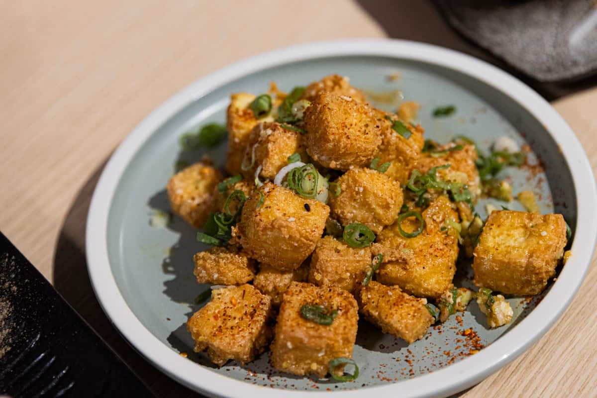Golden pan-fried tofu cubes topped with green onion