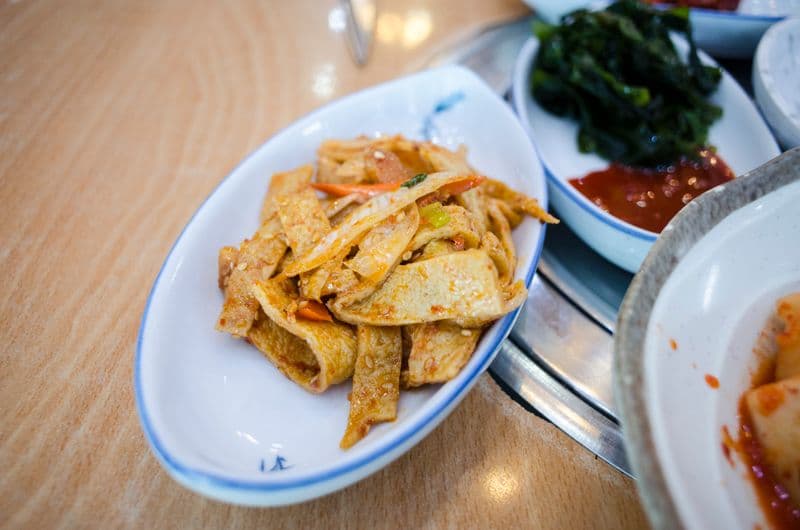 Stir-fried fish cake strips with carrot and sesame seeds in a glossy sauce