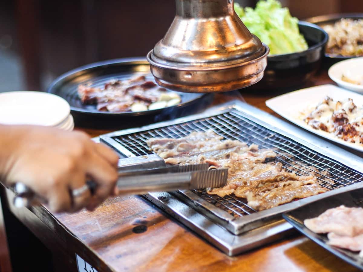 Marinated Korean short ribs grilling on a tabletop grill