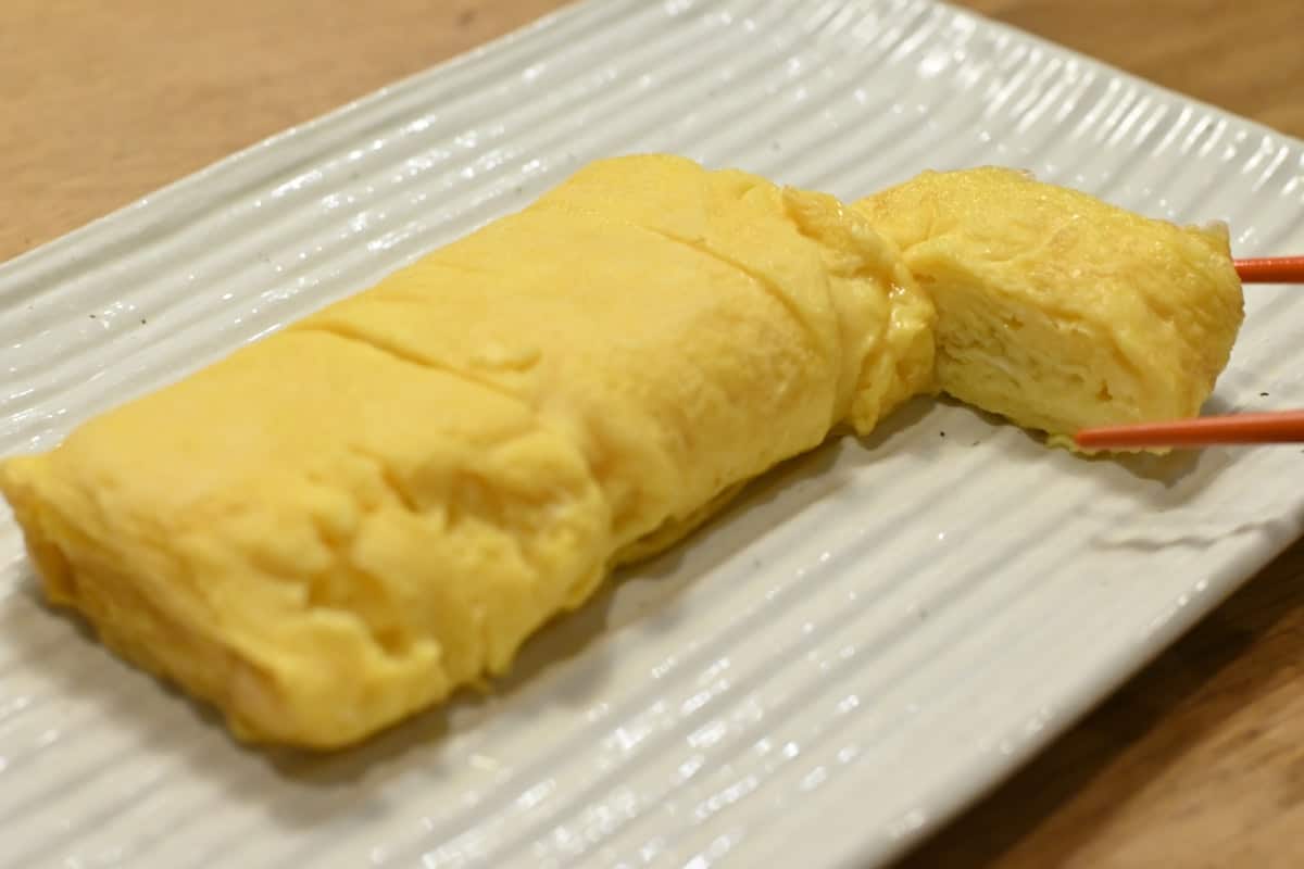 Sliced rolled egg omelette on a plate, showing the layered spiral inside