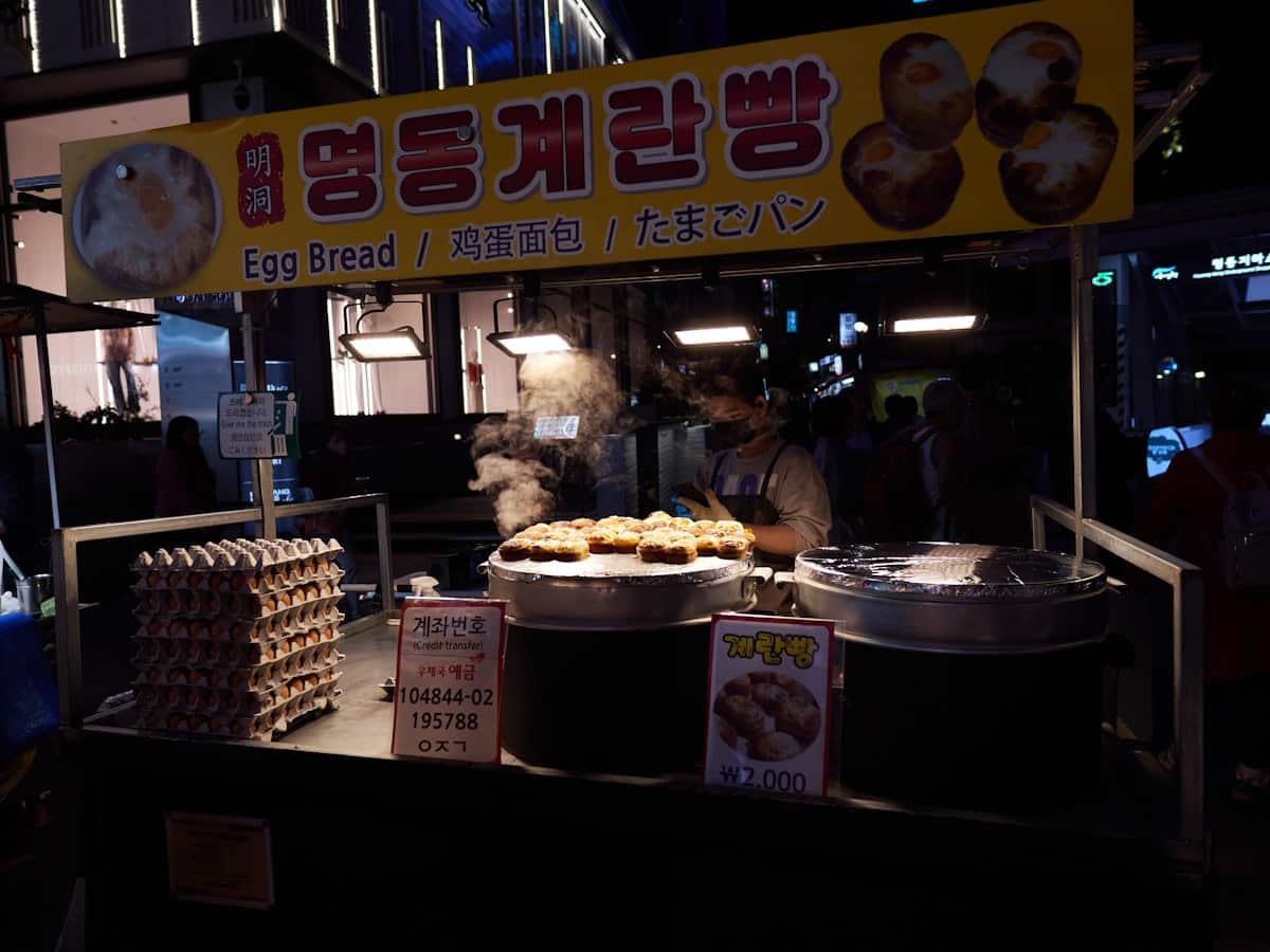 Korean egg bread cooking in round molds on a street-cart griddle