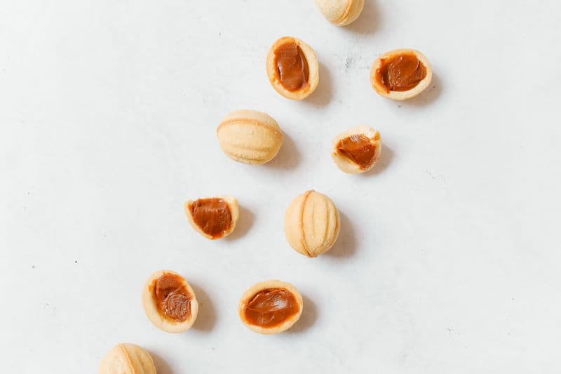 Golden walnut-shaped cakes with visible filling in the cross-section