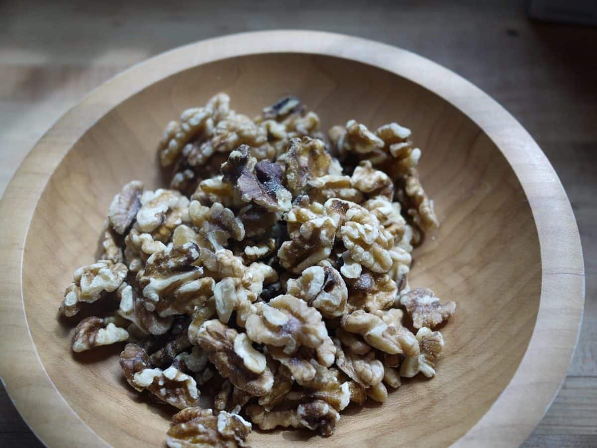 Shelled walnut halves in a wooden bowl
