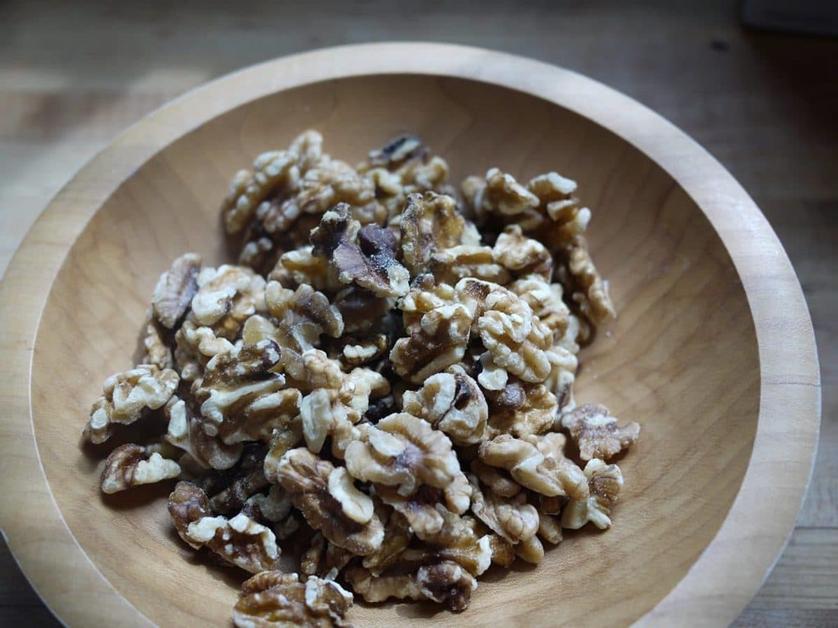 Shelled walnut halves in a wooden bowl