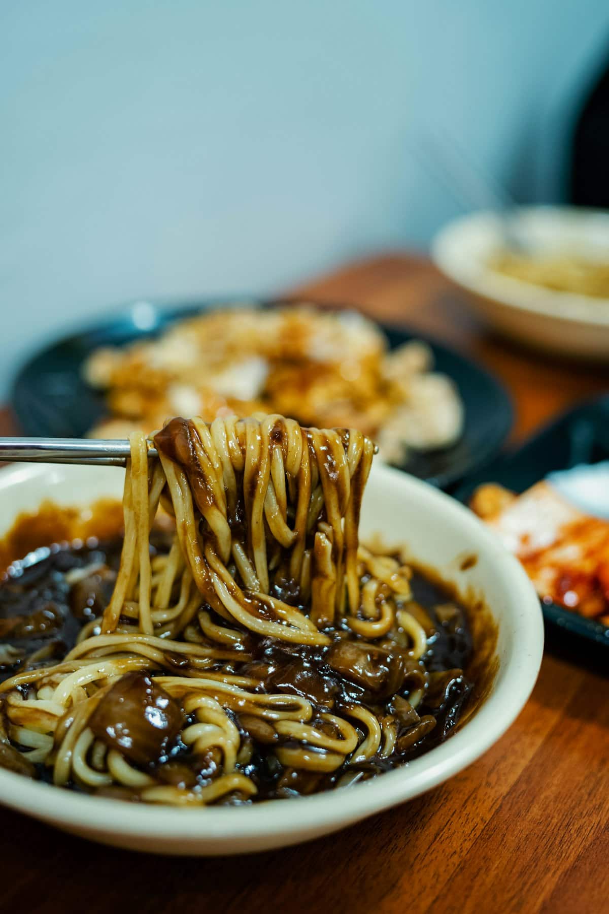 Noodles coated in glossy black bean sauce with diced pork and vegetables