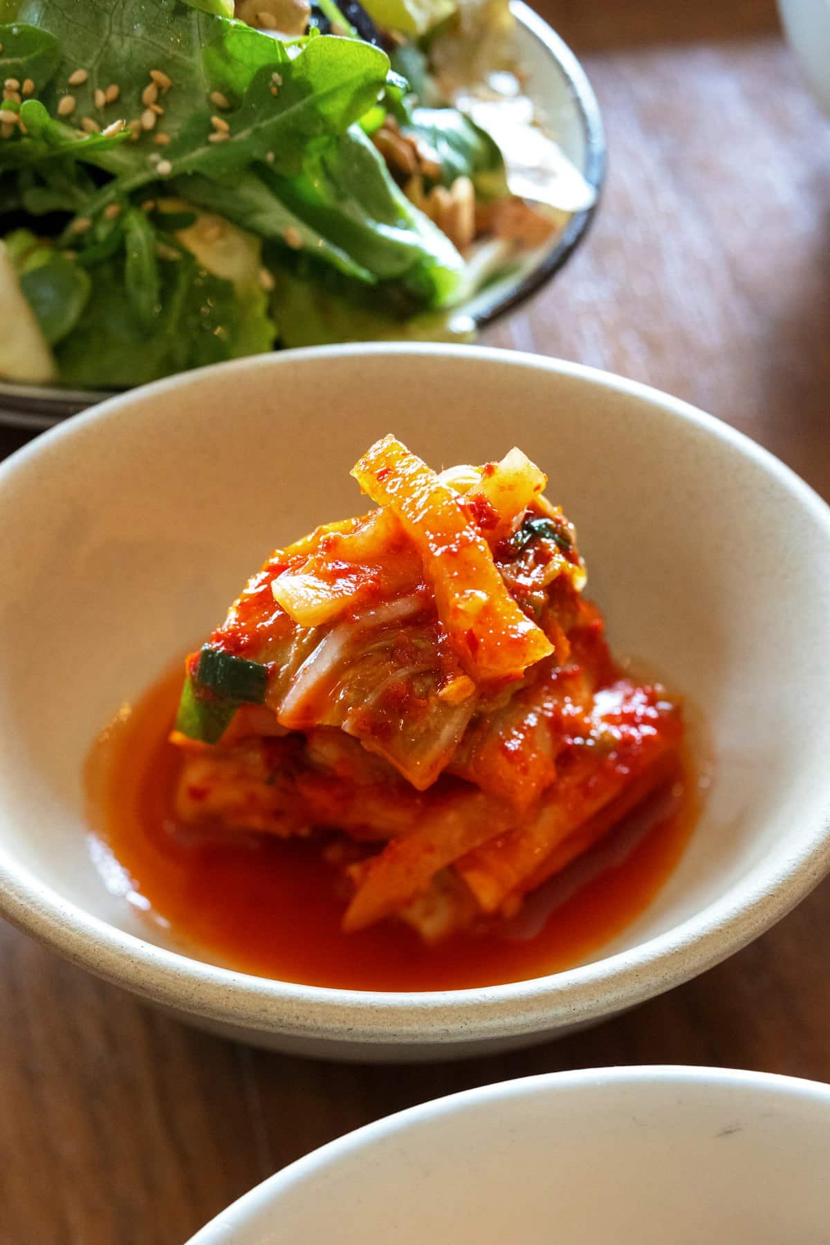 Cubed radish kimchi coated in red chili paste in a bowl