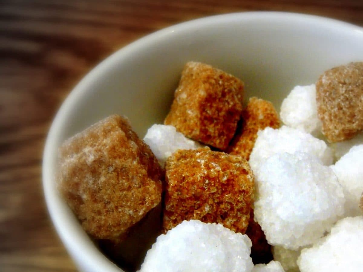 Brown and white sugar cubes in a bowl