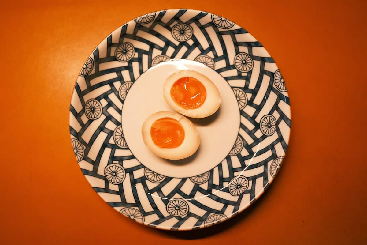 Halved soft-boiled eggs with jammy yolks in a soy marinade